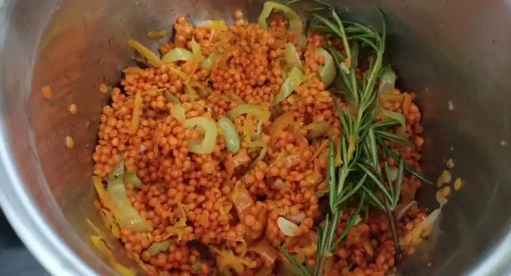 A metal pot with red lentils and other ingredients